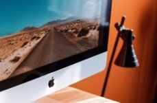 Mac workspace with 4K monitor on a clean wood desk