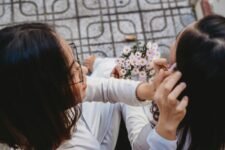 Overhead view of two women sharing a tender moment with flowers.