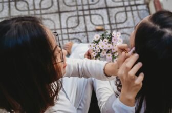 Overhead view of two women sharing a tender moment with flowers.