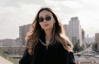 Person wearing sunglasses on a sunny sidewalk