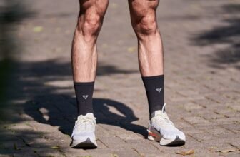 A runner's legs in shorts and sneakers on a sunlit stone pathway, perfect for fitness and outdoors themes.