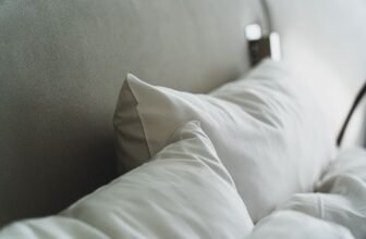 A close-up view of cozy white pillows and bedding in a modern bedroom.