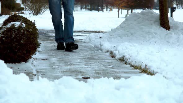 HD video clip of man salting a concrete sidewalk in a suburban neighborhood in Michigan USA, in the