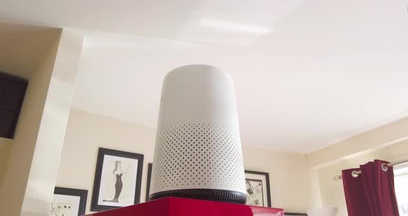 An air purifier sitting in a living room cleaning smoke, dust and pollen etc. from the air